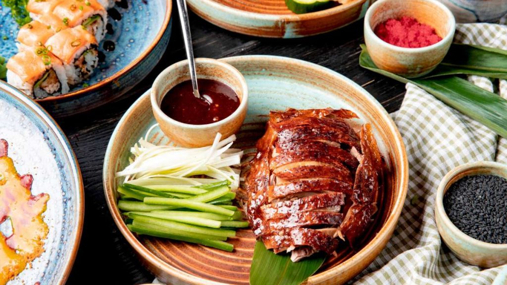 side-view-traditional-asian-food-peking-duck-with-cucumbers-sauce-plate_141793-11572-1200